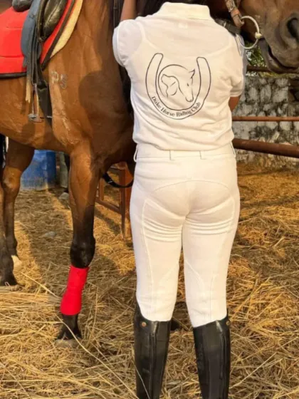 A shot of our club's logo on a rider's shirt as she adjusts the saddle. We are a community.