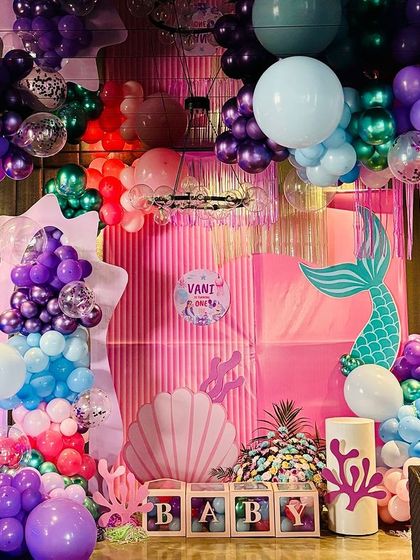 This wide shot captures the full scale of the mermaid-themed balloon decoration, showing how it can transform a room. The balloons appear to float and bubble up to the ceiling, immersing guests in the theme.