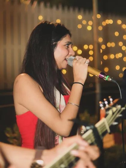 I specialize in low-light party photography, capturing the mood without a harsh flash. This shot of a singer performing at an evening get-together uses the soft background lights to create a warm, atmospheric portrait.