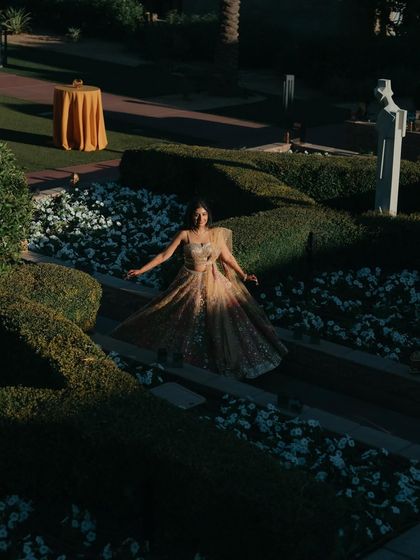 An artistic shot of the bride in a garden, illuminated by a dramatic sliver of sunlight. This high-contrast image creates a stunning and unique bridal portrait.