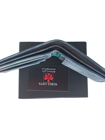 A side view of the denim wallet, showing its slim profile even when filled with cards and cash.