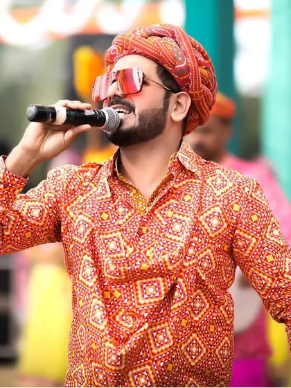 A live singer, dressed in a traditional Bandhani turban, entertains guests at the Rajasthani-themed Mehendi, adding an authentic and energetic musical element.
