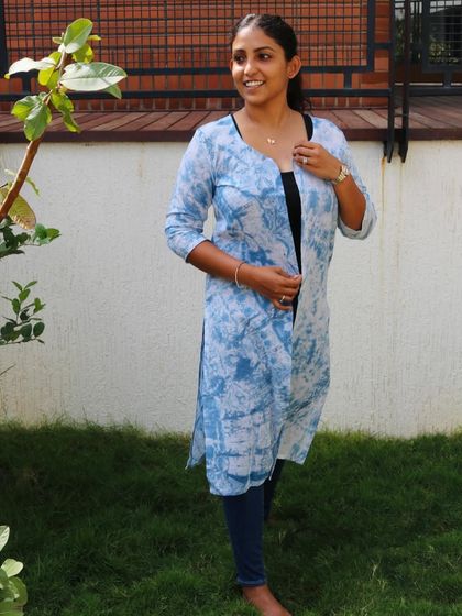 A front view of the 'Indigo Hug' shrug, showing how it can be worn open over a simple top and jeans.