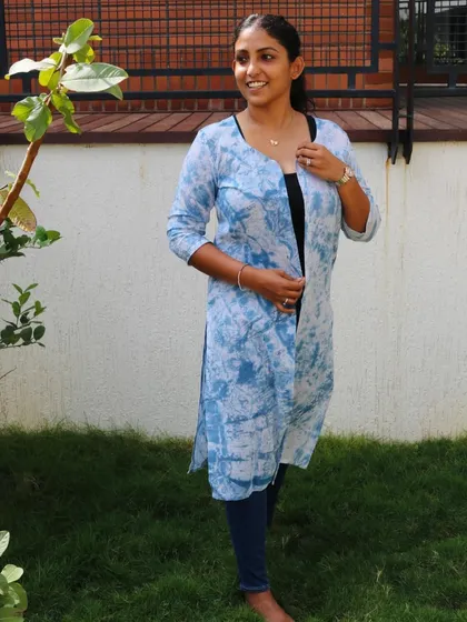 A front view of the 'Indigo Hug' shrug, showing how it can be worn open over a simple top and jeans.