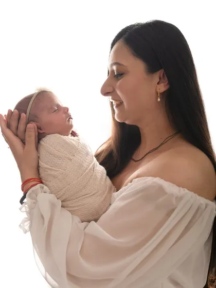 Another beautiful shot of a mother holding her newborn, smiling as she looks at her new baby.