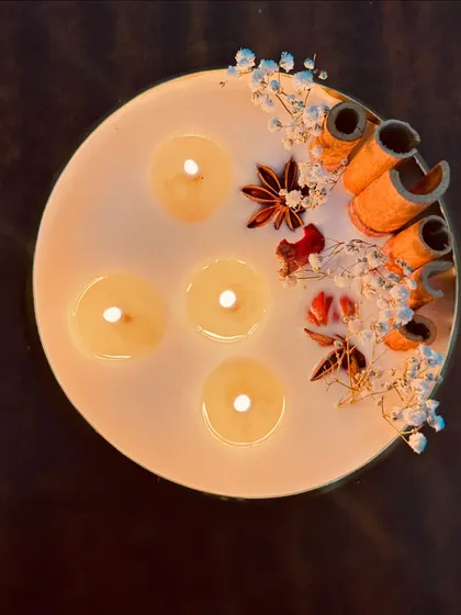 A top-down view of our beautiful spice-adorned urli candle. The multiple wicks ensure an even burn and a beautiful, bright flame.