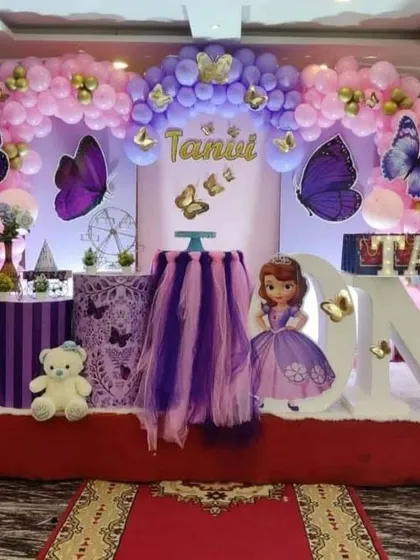 A Sofia the First and butterfly theme in shades of purple and pink. Large 'ONE' letters are decorated with smaller butterflies for a detailed touch.