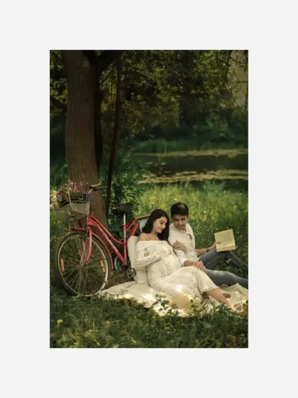 A quiet moment of reading together during their styled picnic. This shot captures the couple's shared interests and the peaceful anticipation of their new life together.