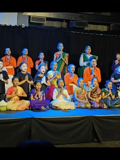 Another view of the full cast on stage, filled with a sense of accomplishment. This image captures the diverse group of children who come together to create something beautiful at Vyoma.