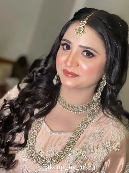 A soft and pretty look for this bride in a peach-colored outfit. The makeup is fresh and dewy, with a glossy lip.