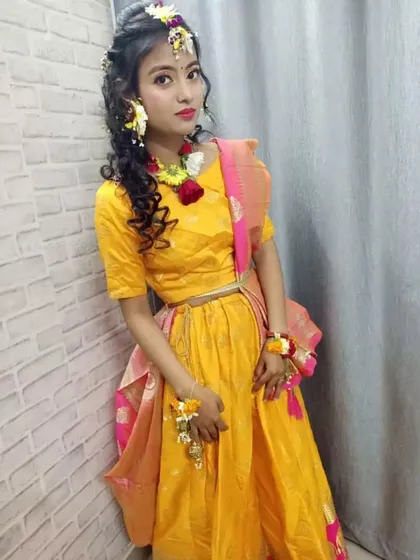 We teach our students specialized event makeup, including this complete Haldi look. This student's work features vibrant eye makeup, soft hairstyling, and the art of creating and placing fresh flower jewelry, a skill highly in demand for pre-wedding functions.