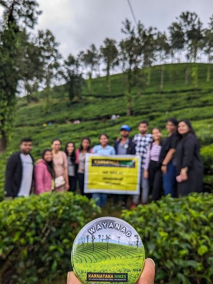 Our Wayanad badge with the tea plantations and our happy group in the background.