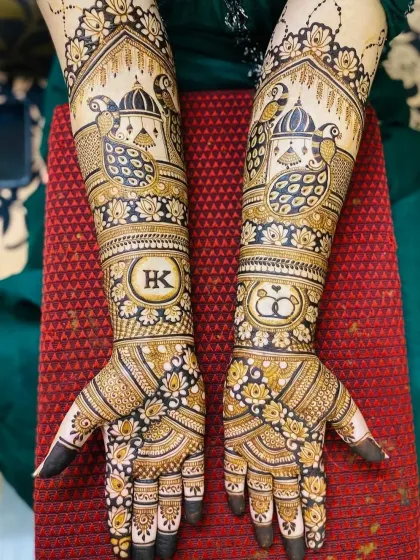 A complete bridal mehndi look combining traditional and personal elements. This design includes peacock and palace motifs, along with the couple's initials "HK" and a symbol of their union with intertwined rings.