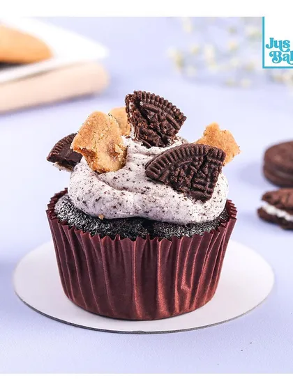A close-up of our Cookies and Cream cupcake. It has a rich chocolate base, is topped with an Oreo-infused cream, and garnished with crushed Oreo cookies for the ultimate treat.