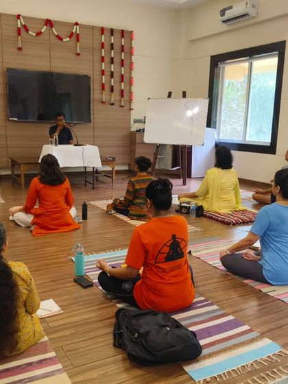 Participants in a Pranayama workshop listen intently to a lecture on the conceptual and scientific basis of breathwork. Learning here combines both theory and practice for a holistic understanding.
