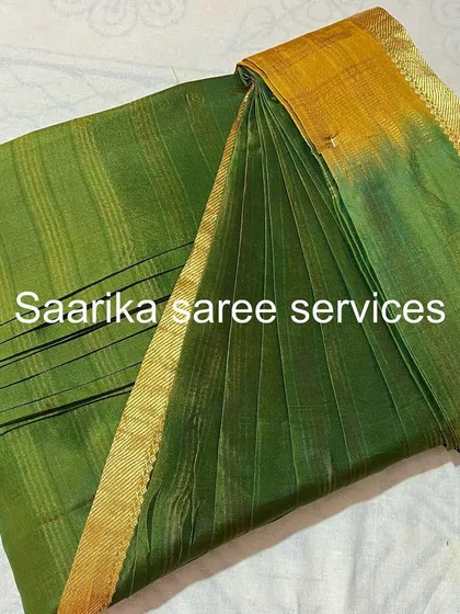 A green handloom saree with a simple gold border.