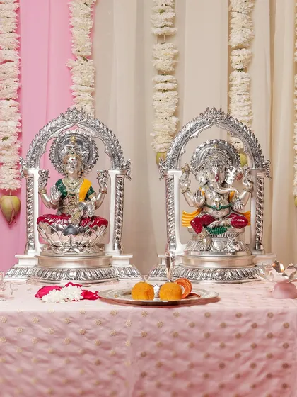 This pair of silver-plated Lakshmi and Ganesha idols, each framed by an elegant arch, creates a harmonious and auspicious display. They are perfect for invoking blessings of wealth and wisdom during festive seasons.