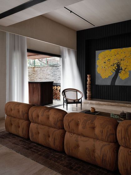 The living room features a bold yellow "Tree of Life" painting, which provides a vibrant splash of color against the dark, fluted wall. The design balances moody tones with bright, artistic statements.