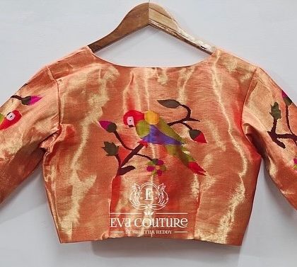 The back view of a pure Paithani handloom silk blouse. The sleeves and back feature colorful, woven parrot motifs, which can be customized in different colors.