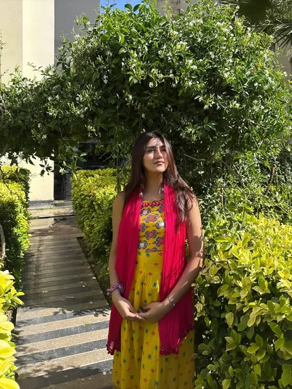 A peaceful moment in a yellow and pink suit, surrounded by greenery. The caption reflects a spiritual and positive mindset.