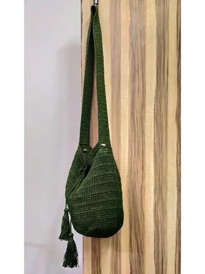 This custom-made jhola bag in a deep olive green features a drawstring closure and handmade tassels. It's a perfect example of how we can tailor a design to your favorite color.