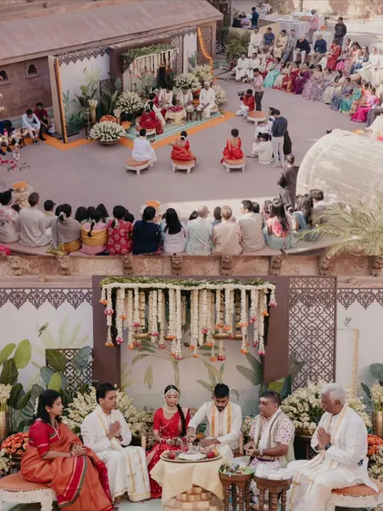 An overview of the South Indian wedding ceremony, capturing the couple, their families, and the guests in a single frame. This shows the full context and atmosphere of the ritual.