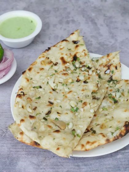 No North Indian meal is complete without a soft, fluffy Garlic Naan. I bake it fresh in the tandoor with chopped garlic and herbs.