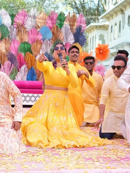 On the mic, leading another fun activity on stage. Keeping the energy up and the activities flowing is key to a successful Haldi.