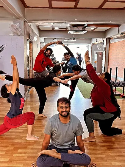 Yoga with us is about connection and having a good time. This picture captures the supportive and playful atmosphere of our group yoga session, where we explore poses together.