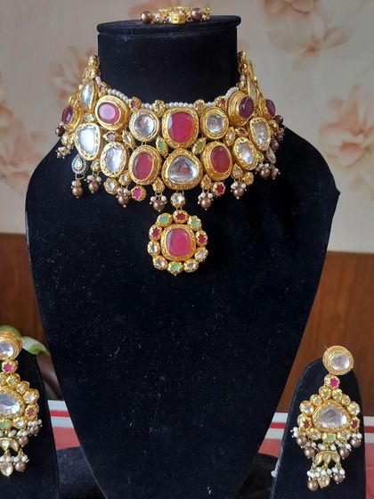 A Kundan choker set with beautiful red and green stones, perfect for a traditional bride.
