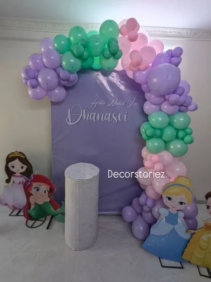 A sweet Disney princess theme for a baby girl's naming ceremony. We created a custom lavender backdrop with the baby's name, an organic balloon arch in pastel colors, and cutouts of beloved princesses.