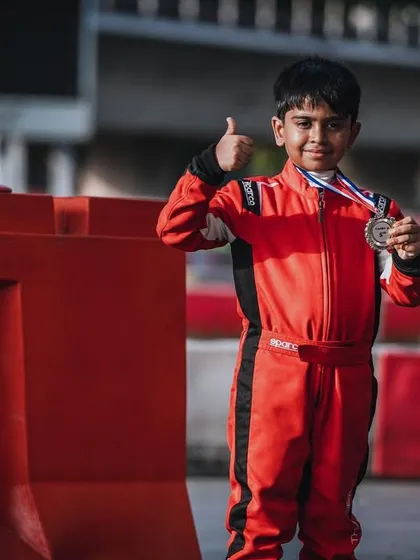 A young driver gives a thumbs-up after securing a medal at the Rok Cup Singapore.