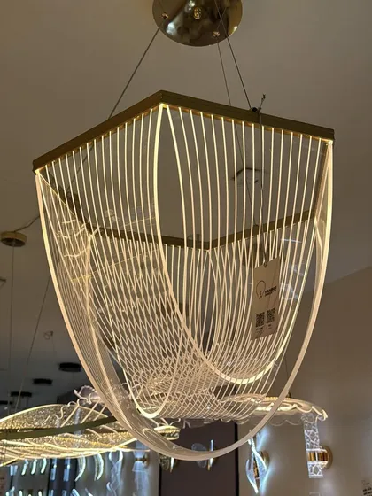 An example of modern art meeting light. This geometric chandelier uses flowing lines of light to create a sense of movement, perfect for a contemporary dining or living space.