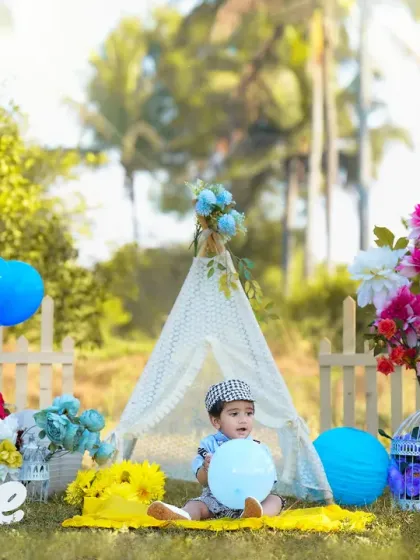 A wide shot of the outdoor setup, showing the baby playing with balloons in a beautiful, park-like setting. Outdoor sessions allow for natural, candid moments and beautiful light.