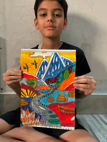 A student proudly holds his imaginative landscape drawing. I encourage my students to develop their own unique style and let their creativity flow freely onto the page.