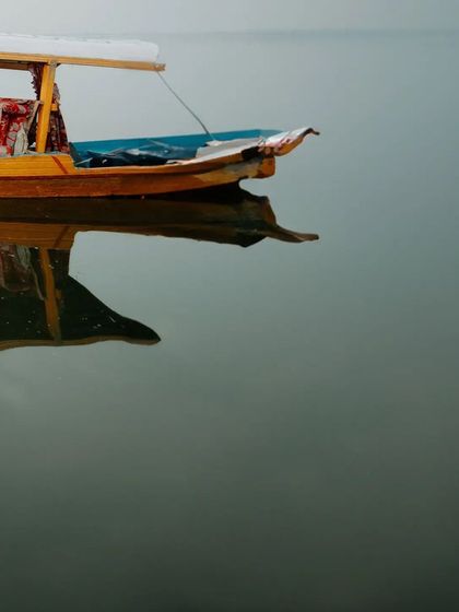 Another minimalist shot focusing on the beauty and tranquility of the Shikara and its reflection, capturing the essence of Kashmir.