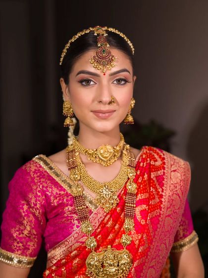 A portrait of timeless beauty. The makeup is perfectly balanced, with defined eyes, a warm complexion, and a natural lip that allows the stunning gold jewellery to take centre stage.