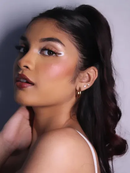 A side profile showing the sleek ponytail and the sharp wing of the eyeliner.