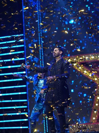 The groom takes the spotlight during his Sangeet performance, surrounded by a shower of golden confetti. I ensure every performance has its own hero moment.