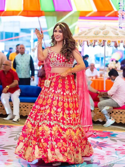 The bride dancing at her Mehendi, her voluminous waves moving with her.