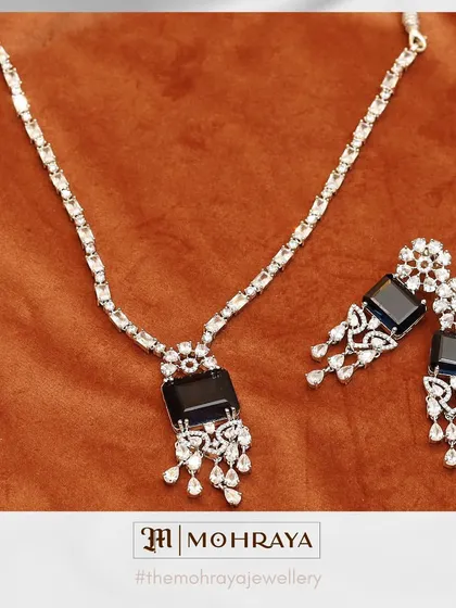 A sophisticated black stone and AD necklace set. The dangling earrings add a touch of drama, making it perfect for an evening event.