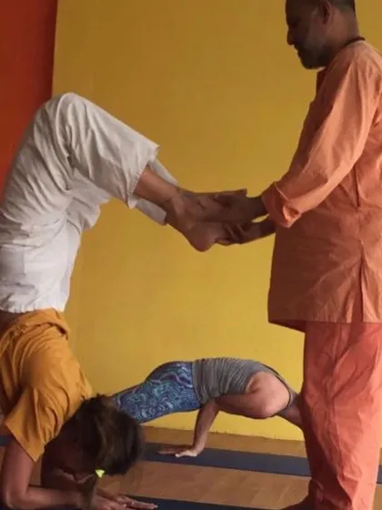 With trust and proper technique, students can assist each other in complex poses like this variation of headstand and arm balance.