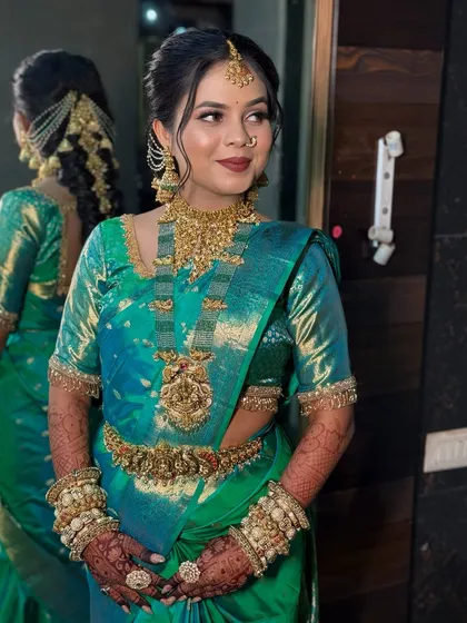 A portrait of the bride in her green saree, looking confident and happy.