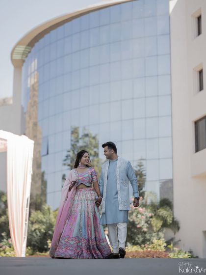 A full-length portrait of the couple taking a stroll, hand in hand. A classic shot that showcases their outfits and the location.