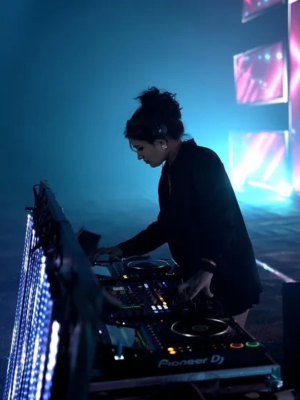 A side profile shot of me at the console on a large stage, surrounded by professional lighting and haze.