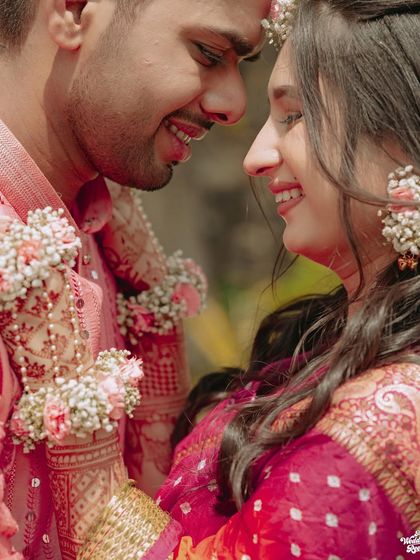 A close-up shot capturing the loving gaze between a couple during their Haldi ceremony, with beautiful floral jewelry details.