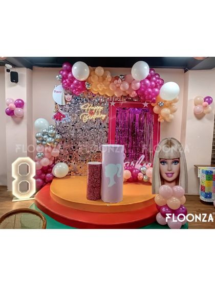 This Barbie-themed stage is perfect for a milestone birthday. I created a glamorous focal point using a silver sequin shimmer wall, a custom neon sign, and a vibrant balloon garland in shades of pink, orange, and white. The setup includes a light-up marquee number '8' and themed pedestals for the cake, making it a complete photo-ready zone.