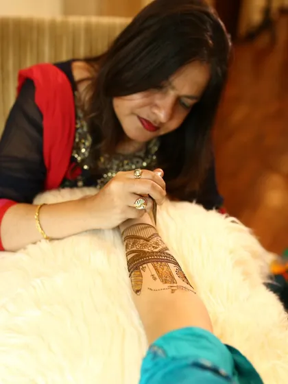 A candid shot of me completely focused on my craft. Applying mehendi is a meditative process that requires immense concentration and a steady hand.