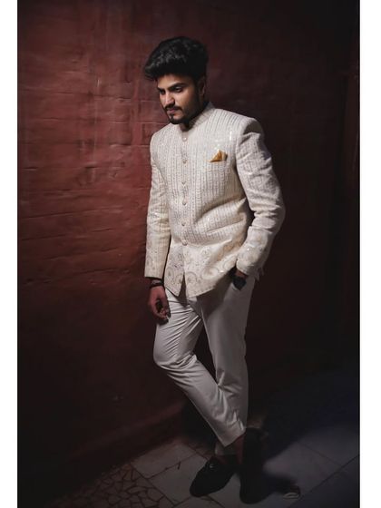 A client looking dapper in an off-white Jodhpuri jacket with all-over embroidery. This is a classic and elegant choice for a festive occasion.