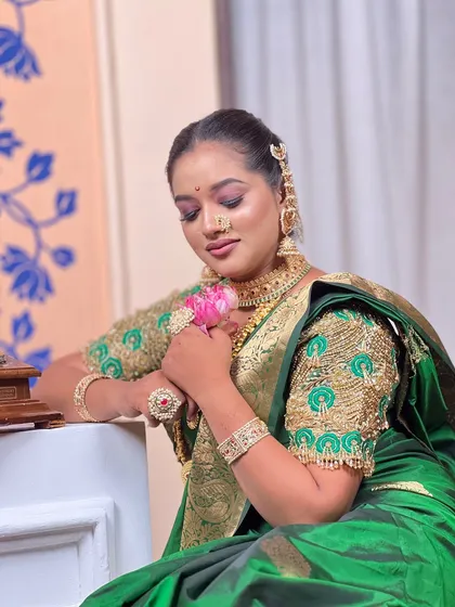 The model posing with a lotus flower, adding a touch of serenity to the traditional 'Rani' look.